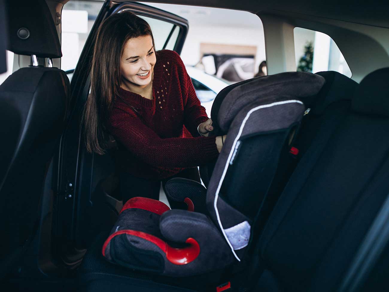 Woman installing a baby seat in car
