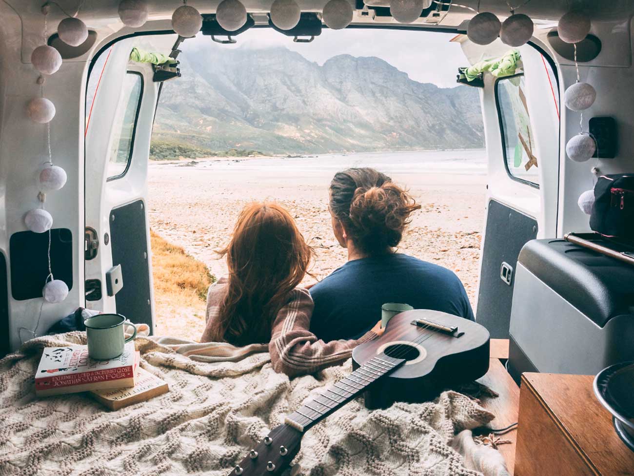 a couple lounging in their van-looking campervan 